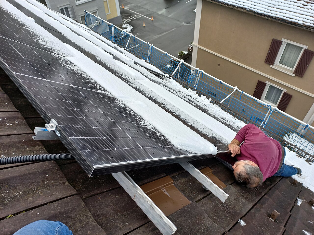 Calculadora y factura eléctrica sobre una mesa junto a un plano de instalación solar